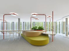 a room with tables, chairs and plants in it