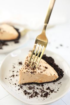 a piece of pie on a white plate with a fork in it and oreo crust