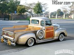 an old truck is parked on the side of the road