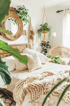 a bed with white linens, pillows and plants in the corner next to it