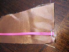 a piece of brown paper with pink ribbon on it