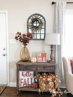 a living room decorated for fall with pumpkins and greenery on the side table