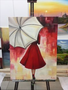 a painting of a woman in a red dress with an umbrella is shown on easel