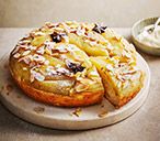 a pastry on a plate next to a bowl of yogurt