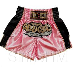 pink and black thai boxing shorts with gold lettering