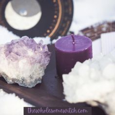 two candles are sitting next to some crystals