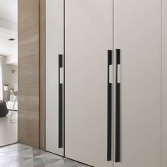 an image of a kitchen setting with white cupboards and black handles on the doors