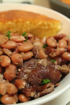 a white bowl filled with beans and meat