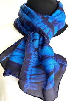 This elegant silk scarf, Connections, features horizontal movements that connect across the scarf. I have created these designs in the Japanese shibori style employing pole wrapping and thread. After this hand dyeing process, the beautiful designs are revealed.  I have named this scarf Connections for the prominent designs appearing throughout - the large bold areas and the connecting subtle ones. Connections will be a mainstay in your wardrobe. Its unique designs that result in the wrapping and dyeing process make Connections very special. I feel the hand of the maker - the beauty that results - connects to the wearer. Also, this dyeing process produces a lush, one-of-a-kind wearable art that will enhance your wardrobe.  Connections is soft and silky to hold and wear. It will make your ou Blue Bohemian Hand Dyed Silk Scarf, Blue Bohemian Hand-dyed Silk Scarf, Artistic Hand Dyed Blue Silk Scarf, Japanese Shibori, Shibori Techniques, Dyeing Process, Shibori, Deep Purple, Silk Scarf