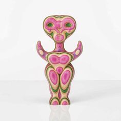 a pink and green figure sitting on top of a table