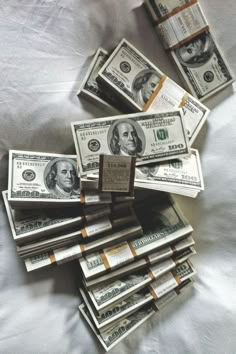 a pile of money sitting on top of a bed