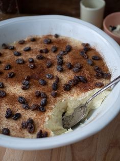 a white bowl filled with food on top of a wooden table