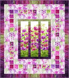 a purple and green quilt with flowers in the window sill on top of it