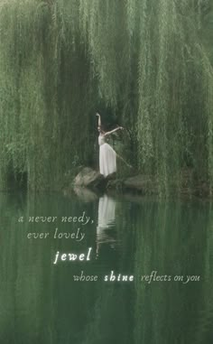 a woman standing on top of a rock in the middle of a river next to green plants