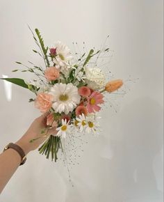 a person holding a bouquet of flowers in their hand