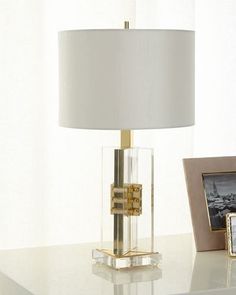 a lamp on a table with a picture frame next to it and an empty photo