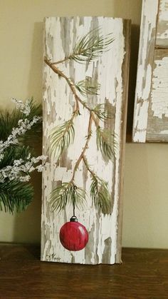 a wooden block with a red ornament hanging from it's side