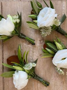 white flowers are arranged on a wooden surface