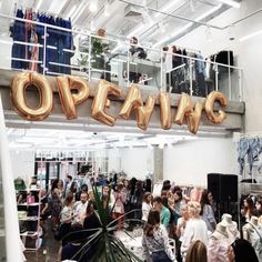 a group of people standing in front of an open sign with the word opening on it