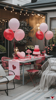 a table with pink and red balloons in the shape of hearts on it is set up for a valentine's day party