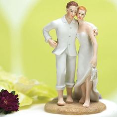 a figurine of two people standing next to each other with flowers in the background