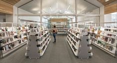 a woman walking through a library filled with lots of books