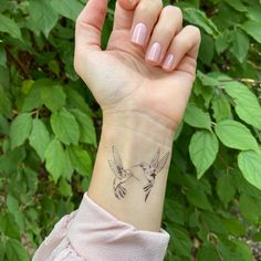 a woman's arm with a small humming tattoo on her left wrist and the word love written across it