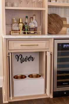 an open cabinet with wine glasses and bottles on it