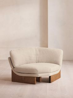 a white couch sitting on top of a hard wood floor next to a tall wall