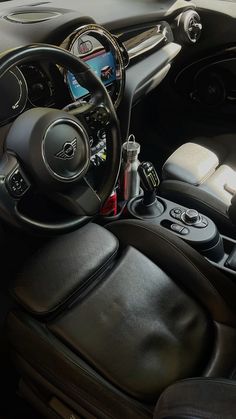 the interior of a car with black leather seats and steering wheel, dash board, and dashboard