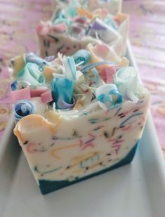 some type of soap that is on a white plate with pink, blue and yellow designs