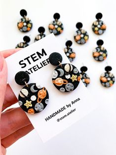 a person holding up a pair of mickey mouse earring on top of a card