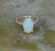 "14K Yellow Gold Opal Ring, medium dome crystal opal cabochon, 4 prong set blue red green fire Australian, 8x12mm, 1/2\" across, Ring size 5.5, Circa 1960, weight 3.2 grams Stock # BB122R04 Most rings are sizable for a small fee. If the ring you are considering is the incorrect size contact us for a quote." Yellow Gold Opal Ring, Opal Band, Opal Ring Gold, Ring Pictures, Domed Ring, Yellow Gold Earring, Opal Crystal, Fine Jewelry Designers, Earring Backs