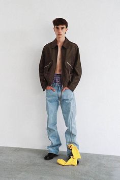 a man standing in front of a white wall with a banana peel on the floor