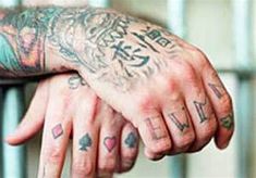 a man with lots of tattoos on his arm holding onto another person's hand