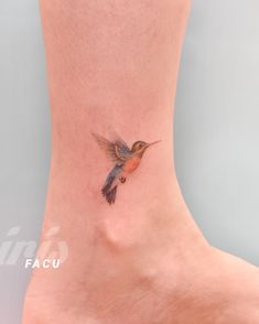 a small tattoo on the ankle of a woman's foot with a hummingbird