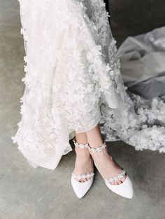 the bride's shoes are all white and they have beaded straps on them