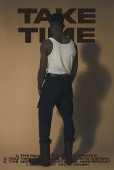 a man standing in front of a wall with the words take time on it