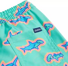 a pair of blue and pink swim trunks with sharks on them