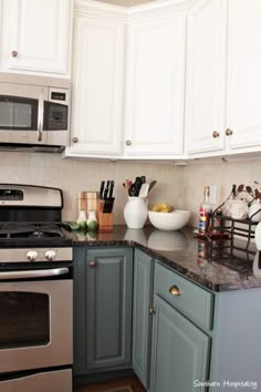 a kitchen with white cabinets and gray counter tops, silver appliances and stainless steel stove