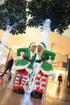 two people dressed in christmas costumes standing next to each other