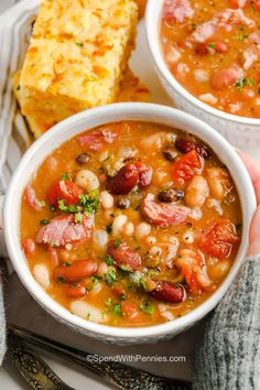 two white bowls filled with soup next to bread