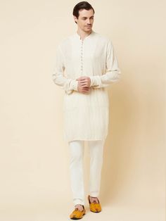 This White Sequins kurta will instantly give an elegant look. Made from polyester cotton fabric, this 2 piece kurta set features a white sequins kurta, front buttons fastening, designer cuff buttons, and a mandarin collar. This white kurta has beautiful vertical stripe sequins embroidery work all over. It is paired with white churidar pants. An ideal outfit for traditional & special events.

Size Chart For Men





	
	
					Men's Size Chart
		

		
		
						
				Size Chart For Men
				Custom Size Elegant Cotton Bandhgala Straight Kurta, Fitted Off White Kurta For Transitional Season, Festive Elegant Cotton Kurta, Cotton Bollywood Bandhgala With Long Sleeves, Elegant Cotton Bandhgala With Long Sleeves, Transitional Long Sleeve Cotton Churidar, Designer Straight Kurta In Off White, Off White Straight Kurta, Festive Off-white Cotton Silk Kurta