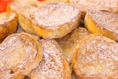 powdered sugar donuts on a wooden cutting board