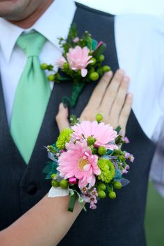 the bride and groom are holding their bouquets with pink flowers on them as they stand close to each other