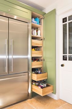 a stainless steel refrigerator freezer sitting inside of a kitchen next to a wooden drawer