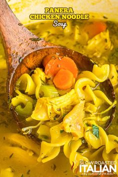 a wooden spoon filled with pasta and carrots in a broth type soup recipe