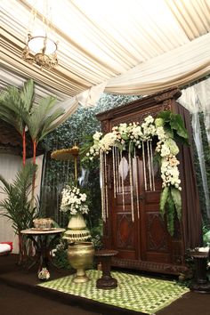 a room decorated with flowers and greenery