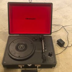 an old record player sitting on the floor with its case open and wires plugged into it