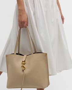 Rebecca Minkoff "Megan" tote bag in calf leather     Shoulder straps, 10" drop    Open top with lobster clasp strap closure     Interior, one slip pocket     Approx. 11.5"H x 14"W x 5.8"D    Item Weight (Lbs.): 2.0    Imported Chic Beige Bag With Palladium Hardware, Calf Leather Bucket Bag With Gold-tone Hardware For Workwear, Chic Satchel With Palladium Hardware For Everyday Use, Everyday Shoulder Bag With Double Handle And Palladium Hardware, Chic Bags With Palladium Hardware For Daily Use, Chic Satchel With Gold-tone Hardware Tote, Timeless Bags With Palladium Hardware For Everyday Use, Chic Tote Satchel With Gold-tone Hardware, Chic Calf Leather Shoulder Bag With Handle Drop